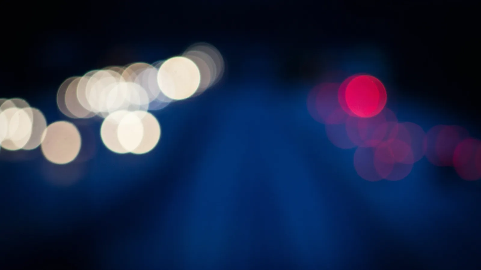 Unscharfe blaue und weiße Lichter bei Nacht.